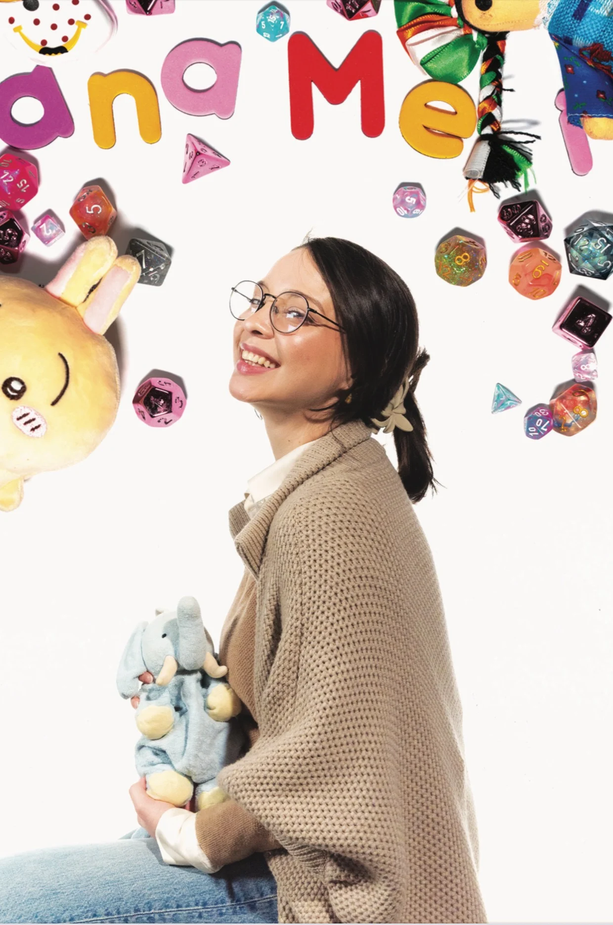 Ana Meli Olivo, seated and smiling, holding a plush elephant